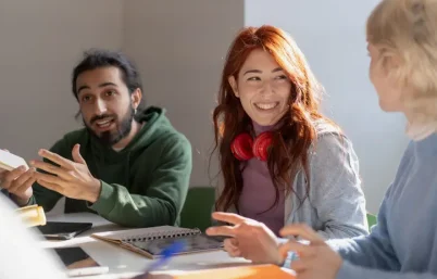 Small group of young adults smiling and studying together.
